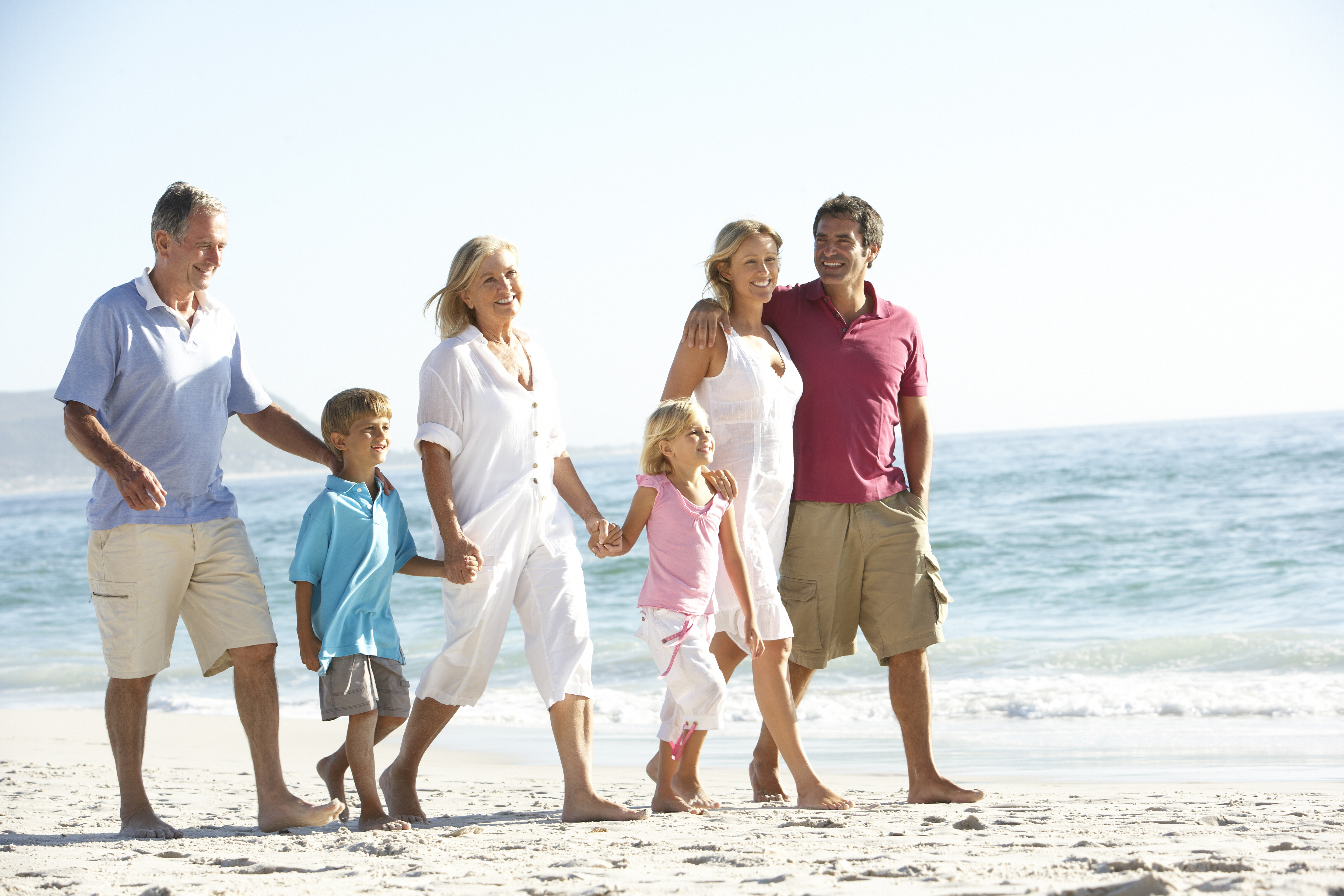 Three Generation Family Walking On Beach